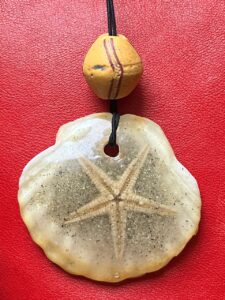Création personnelle, étoile des mers, sable, résine, coquillage, perle africaine ancienne. Création personnelle, étoile des mers, sable, résine, coquillage, perle africaine ancienne.